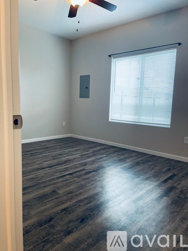 A room with a ceiling fan and a window with blinds.