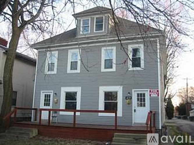 A house with a grey facade and a red fence.