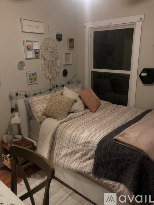 A bedroom with a bed, a chair, and pictures on the wall.