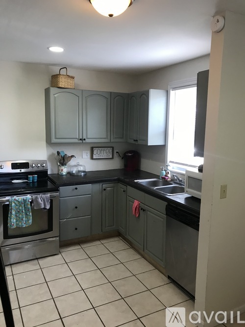 A kitchen with a black counter top and white cabinets.