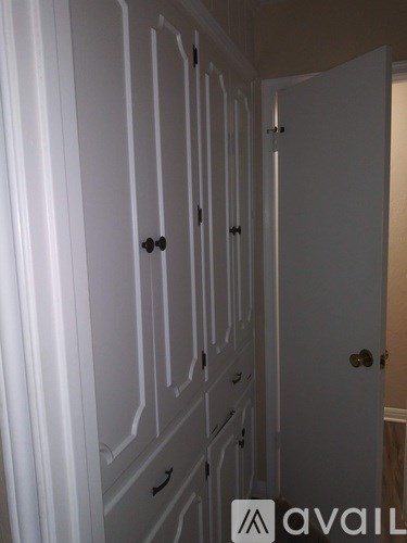 A row of white doors with black handles.