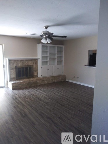 A room with a fireplace and a fan on the ceiling.
