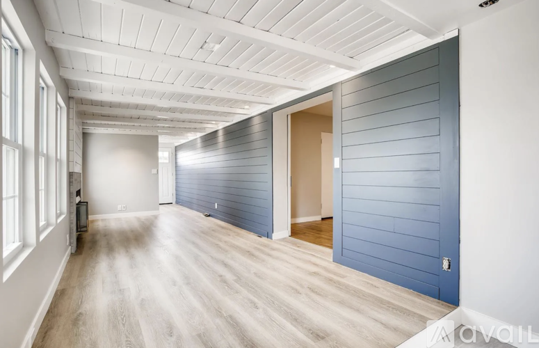 A spacious room with a blue wall and a white ceiling.