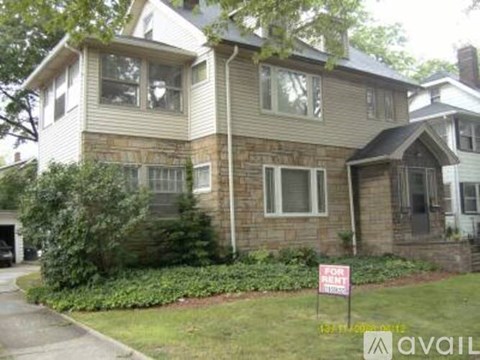 A house with a sign in front of it that says "For Sale".