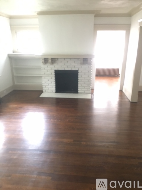 A room with a fireplace and wooden floors.