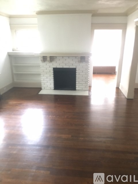 A room with a fireplace and wooden floors.