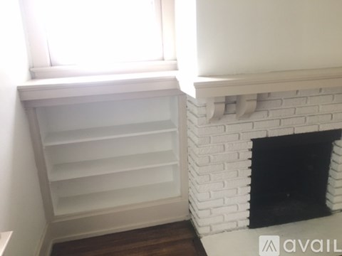 A white fireplace with a black fireplace screen.
