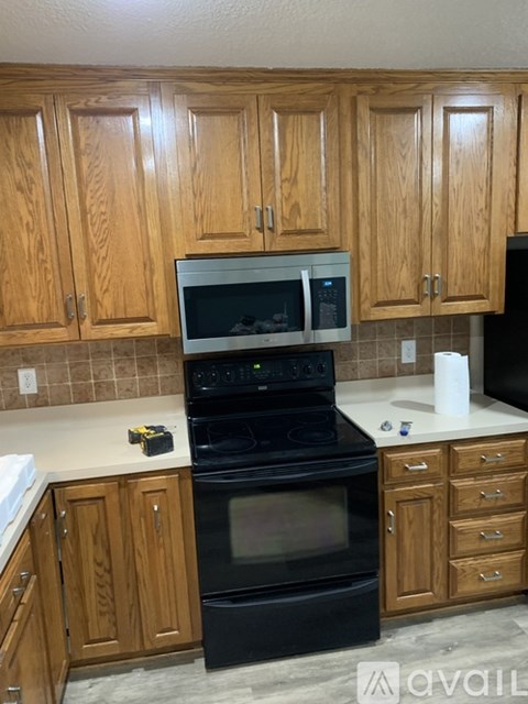 A kitchen with wooden cabinets and a black oven.