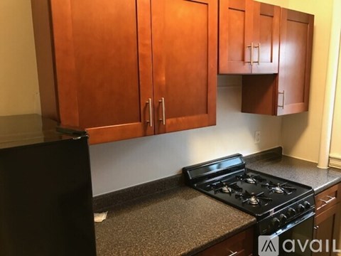 A kitchen with a black stove and wooden cabinets.