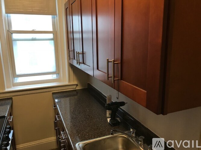 A kitchen with brown cabinets and a stainless steel sink.