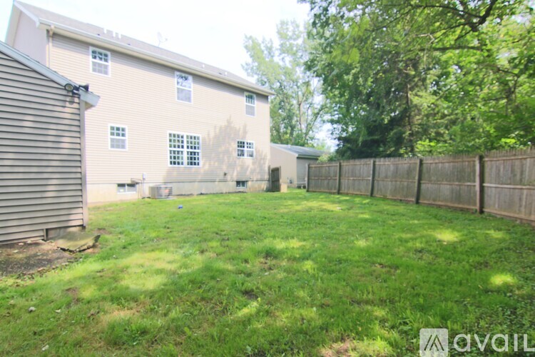 A backyard with a fence and a building in the background.