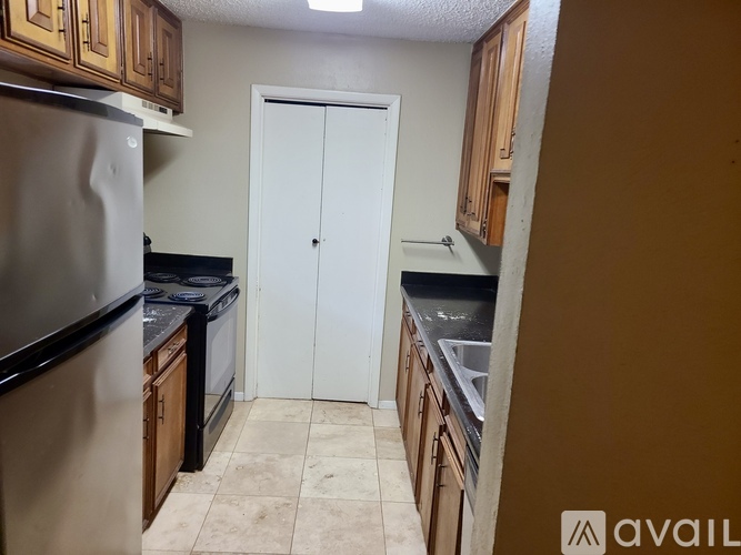A kitchen with wooden cabinets and a stainless steel refrigerator.