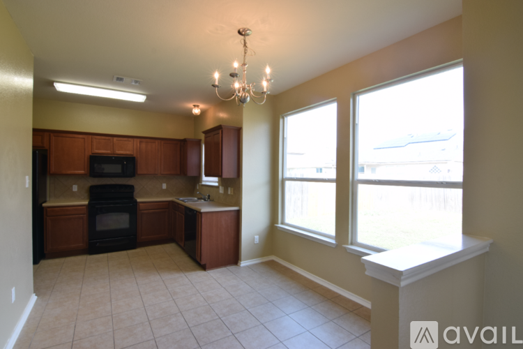 A kitchen with brown cabinets and a black oven.