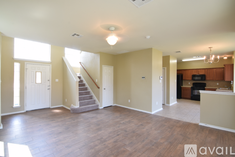 A spacious living room with a staircase leading to the upper floor.