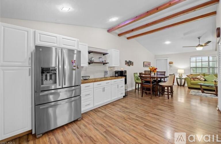 A kitchen with white cabinets and a wooden floor.