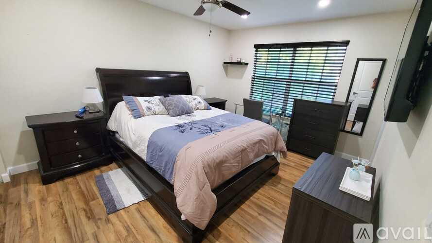 A bedroom with a large bed and a wooden floor.