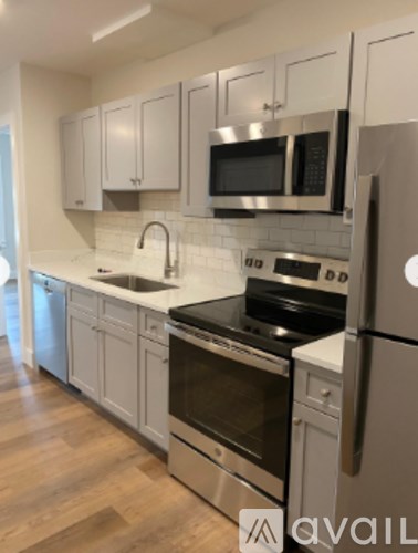 A kitchen with stainless steel appliances and white cabinets.
