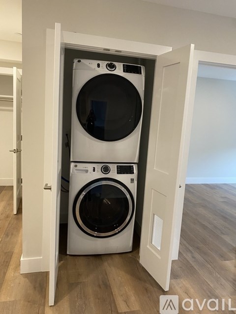 A white washer and dryer are stacked in a small space.