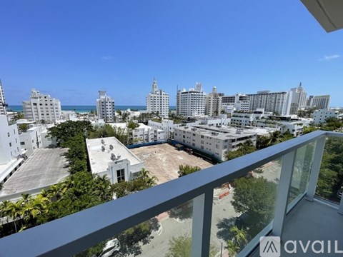 A balcony overlooks a cityscape with buildings and palm trees.