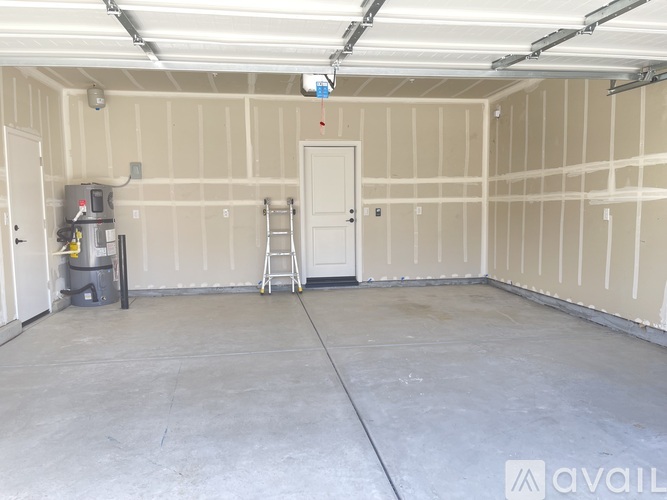 A spacious garage with a concrete floor and walls covered in insulation.