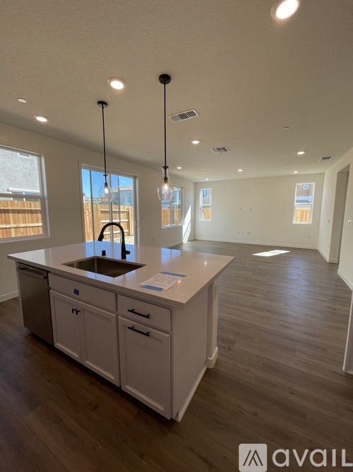 A kitchen with white cabinets and a wooden floor.