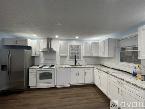 A modern kitchen with white cabinets and stainless steel appliances.