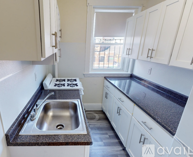 A kitchen with white cabinets and a granite countertop.