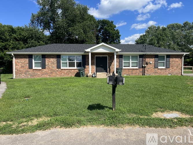 A house with a green lawn and a mailbox in front.