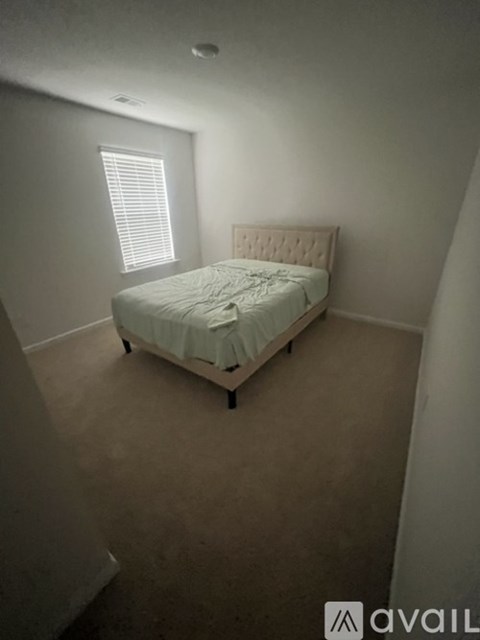 A bedroom with a bed and a window.