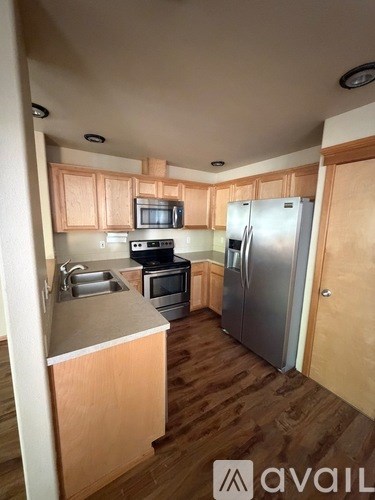 A kitchen with wooden cabinets and a refrigerator.