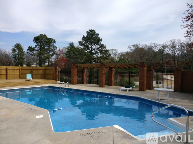A pool surrounded by a fence and trees.