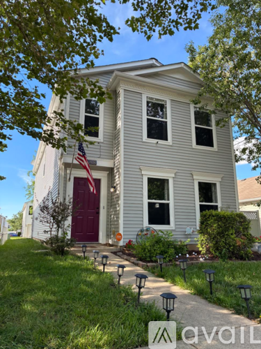 A house with a red door and an American flag on the front.