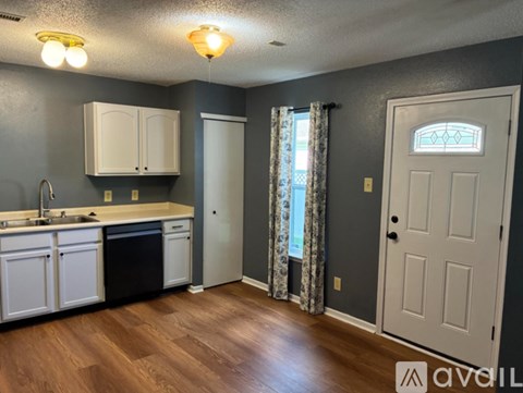 A kitchen with white cabinets and a black dishwasher.