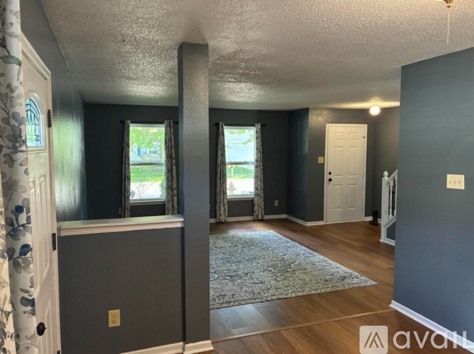 A room with a grey cabinet and a window with a view of trees.