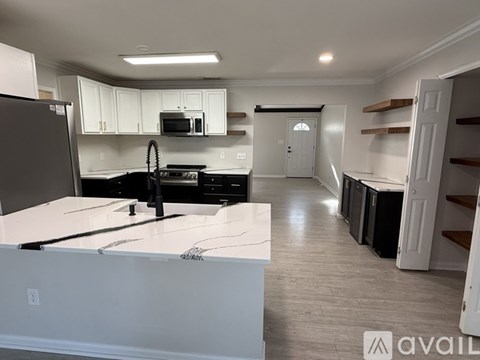A kitchen with white cabinets and a black stove top oven.