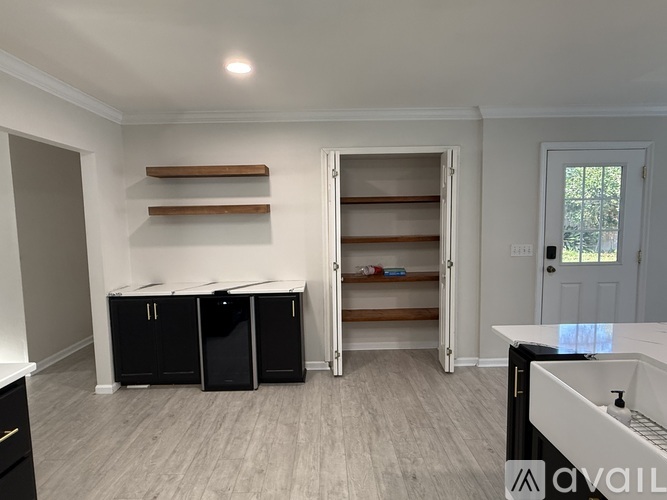 A room with a white door, a white table, and a white cabinet.