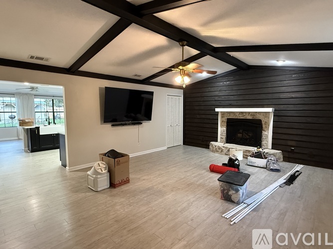 A living room with a fireplace and a flat screen TV mounted on the wall.