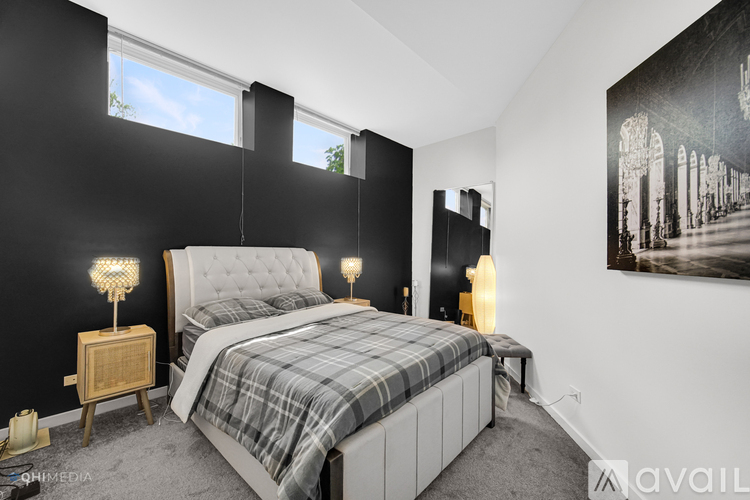 A bedroom with a bed, nightstands, and a painting on the wall.