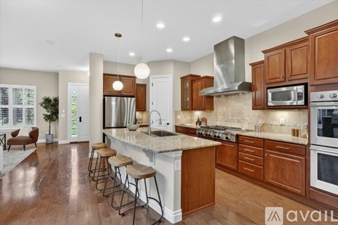 A modern kitchen with wooden cabinets and stainless steel appliances.