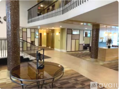 A spacious lobby with a glass table and a staircase.