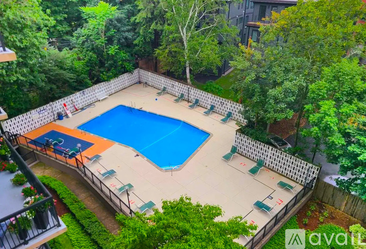 A small pool surrounded by a fence and trees.