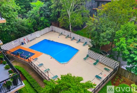 A small pool surrounded by a fence and trees.