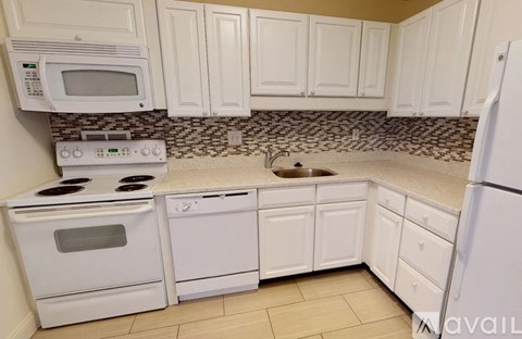 A kitchen with white appliances and cabinets.