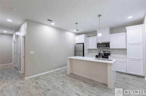 A kitchen with white cabinets and a countertop is available for rent.