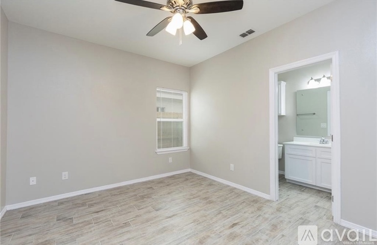 A room with a ceiling fan and a doorway leading to another room.