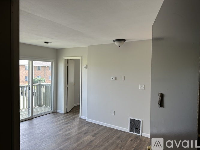 A room with a sliding glass door leading to a balcony.