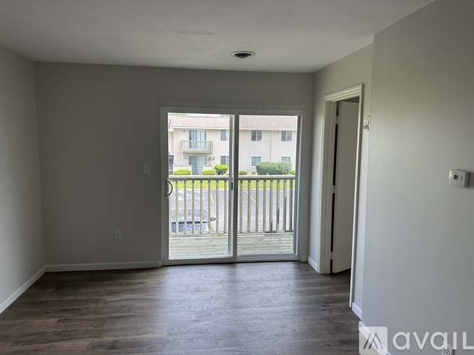 A spacious room with a view of a balcony and a building outside.