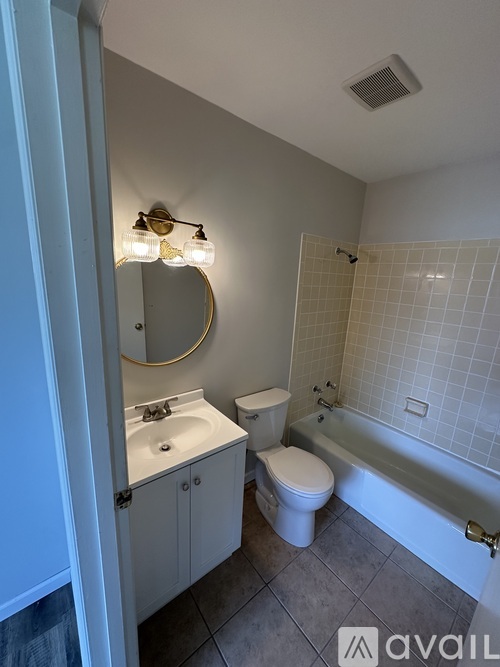 A bathroom with a toilet, sink, and bathtub.