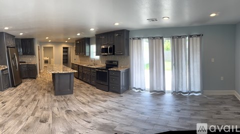 A spacious kitchen with dark wood cabinets and a large island.