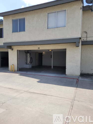 A two-story house with a garage and a driveway.